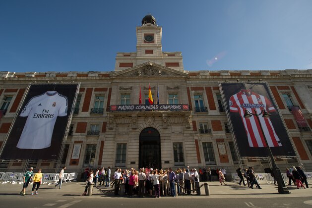 MADRID, SPAIN - MAY 14:  Real Madrid CF and Club Atletico de Madrid shirt banners hang from the regional Madrid government building at Puerta del Sol square on May 14, 2014 in Madrid, Spain.   Preparations are being made ahead of the all-Madrid UEFA Champions League final on May 24 in Lisbon.  (Photo by Denis Doyle/Getty Images)