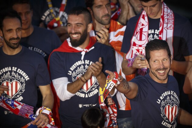 Atletico's coach Diego Simeone from Argentina, right, points his finger as he celebrates the Spanish first division title ''La Liga'' with his team players at the Neptuno fountain in Madrid, Sunday May 18, 2014. A 1-1 draw against Barcelona on the last match gave Atletico its first La Liga title in 18 years. (AP Photo/Daniel Ochoa de Olza)