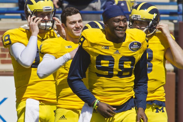 Michigan quarterback Shane Morris, center, lines up behind quarterback Devin Gardner (98) before team stretches, during the football team's annual spring game, Saturday, April 5, 2014, in Ann Arbor, Mich. (AP Photo/Tony Ding)