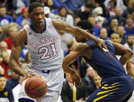 Kansas center Joel Embiid (21) pushes off West Virginia forward Devin Williams, right, during the first half of an NCAA college basketball game in Lawrence, Kan., Saturday, Feb. 8, 2014. Embiid scored 11 points in the game. Kansas defeated West Virginia 83-69. (AP Photo/Orlin Wagner)