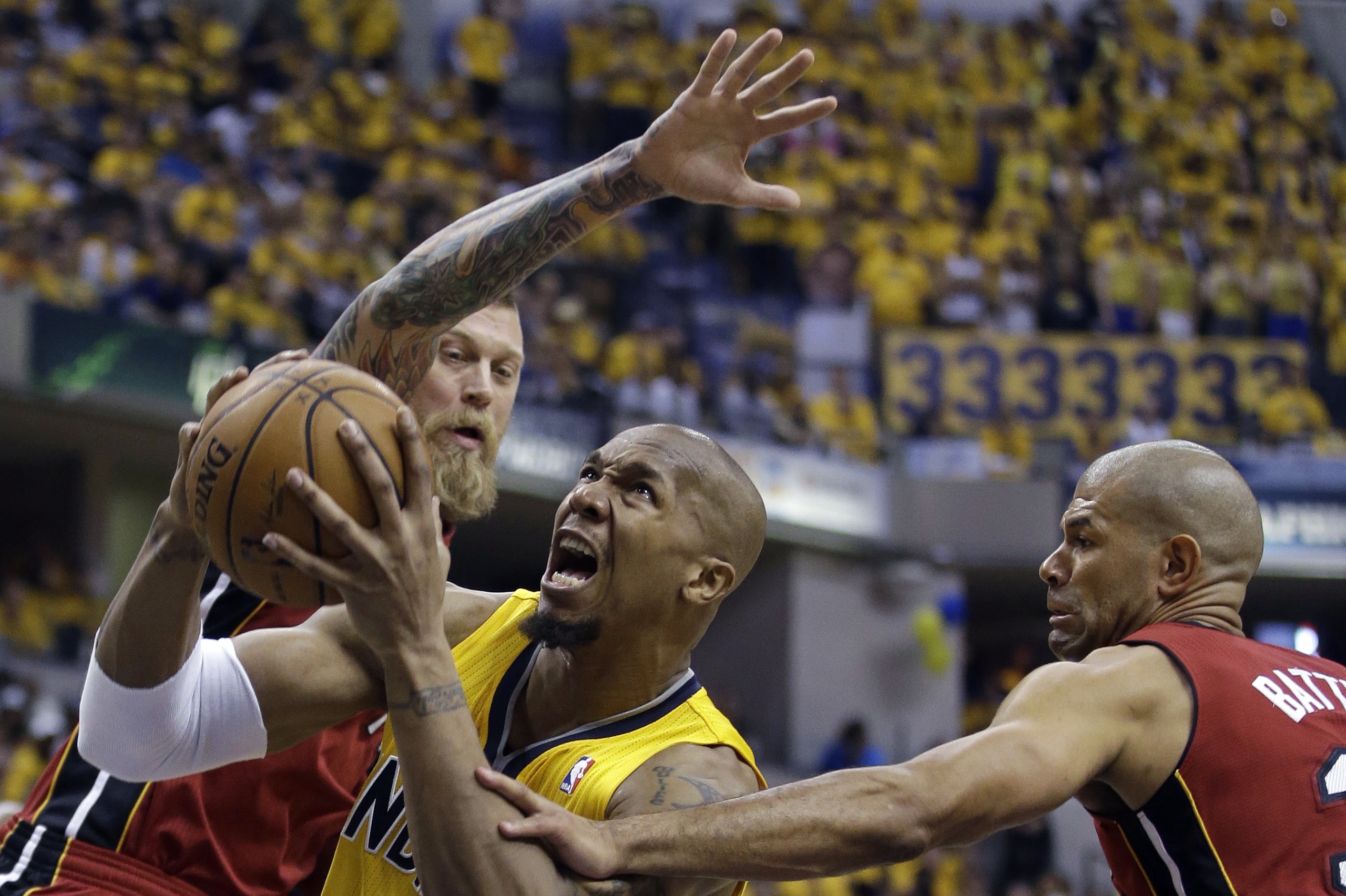 Indiana Pacers' David West (21) puts up a shot against Miami Heat's Chris Andersen and Shane Battier, right, during the second half of Game 1 of the Eastern Conference finals NBA basketball playoff series, Sunday, May 18, 2014, in Indianapolis. (AP Photo/Darron Cummings)