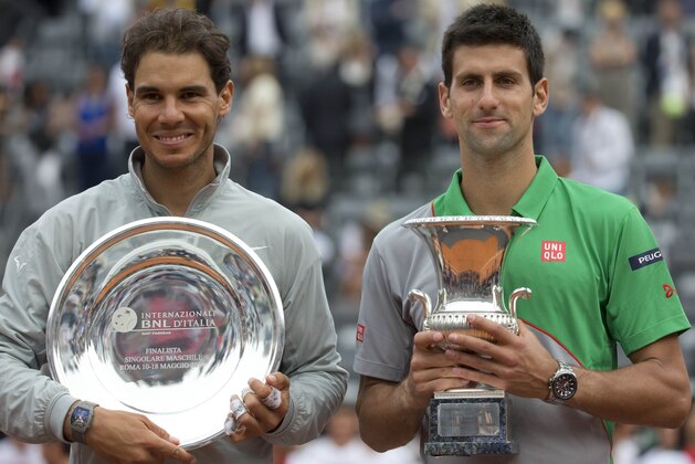 Serbia's Novak Djokovic, right, holds the winner's trophy, as Spain's Rafael Nadal holds the second placed trophy during the awarding ceremony of the Italian Open tennis tournament, in Rome, Sunday, May 18, 2014. Novak Djokovic extended his recent dominance over Rafael Nadal by rallying for a 4-6, 6-3, 6-3 victory Sunday to win the Italian Open for the third time. (AP Photo/Andrew Medichini)