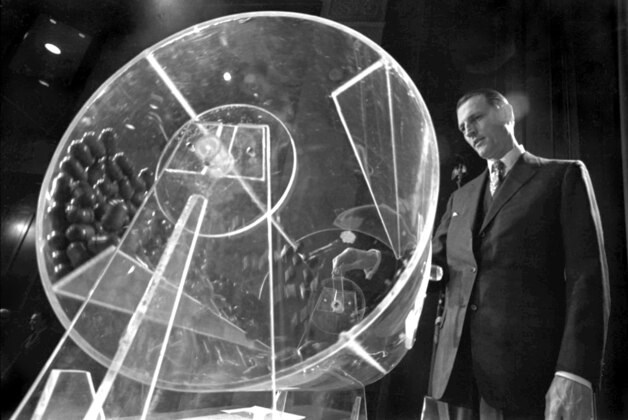 FILE - In this Feb. 2, 1972, file photo Draft Director Curtis W. Tarr spins a plexiglass drum containing capsules with birth dates and orders of assignments for men born in 1953 at the beginning of the fourth annual Selective Service lottery in Washington. Tarr, the man who developed the lottery for the draft during the Vietnam War, died Friday of pneumonia  at his home in Walnut Creek, Calif., his daughter Pam Tarr said Wednesday, June 26, 2013. He was 88. (AP Photo, Charles W. Harrity, File)