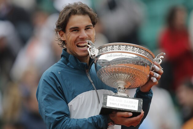 Spain's Rafael Nadal bites the trophy after winning against compatriot David Ferrer in three sets 6-3, 6-2, 6-3, in the final of the French Open tennis tournament, at Roland Garros stadium in Paris, Sunday June 9, 2013. (AP Photo/Christophe Ena)