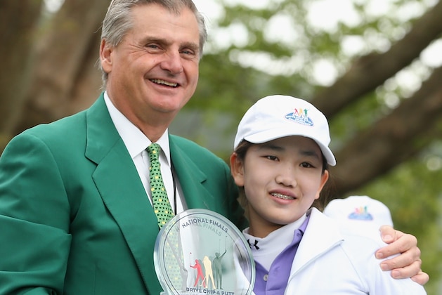 AUGUSTA, GA - APRIL 06:  Lucy Li of Southern California receives her trophy from an Augusta National member after winning the Girls 10-11 category at the National Finals of the Drive, Chip and Putt Championship at Augusta National Golf Club on April 6, 2014 in Augusta, Georgia.  (Photo by Andrew Redington/Getty Images)