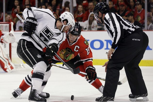 Los Angeles Kings' Mike Richards (10), left, and Chicago Blackhawks' Jonathan Toews (19) battle for the puck during the third period of Game 1 of the Western Conference finals in the NHL hockey Stanley Cup playoffs in Chicago on Sunday, May 18, 2014. The Blackhawks won 3-1. (AP Photo/Nam Y. Huh)
