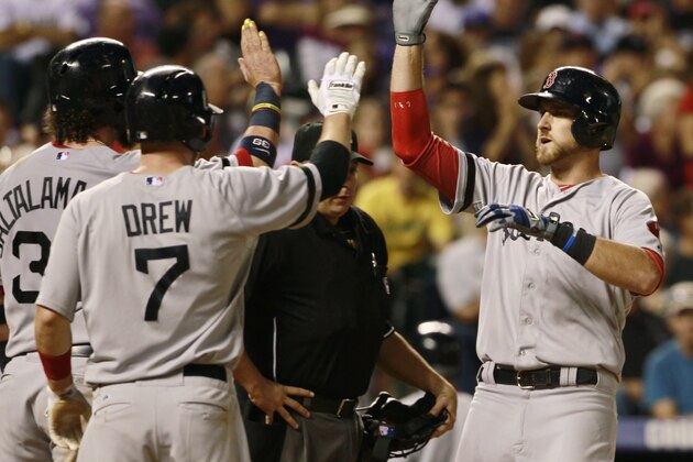 Boston Red Sox's Jarrod Saltalamacchia, left, and Stephen Drew, center, congratulate Will Middlebrooks as he crosses home plate after hitting a three-run home run against the Colorado Rockies in the fifth inning of the Red Sox's 15-5 victory in a baseball game in Denver on Wednesday, Sept. 25, 2013. (AP Photo/David Zalubowski)