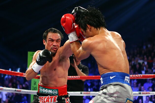 LAS VEGAS, NV - DECEMBER 08:  (L-R) Juan Manuel Marquez throws a left at Manny Pacquiao during their welterweight bout at the MGM Grand Garden Arena on December 8, 2012 in Las Vegas, Nevada.  (Photo by Al Bello/Getty Images)