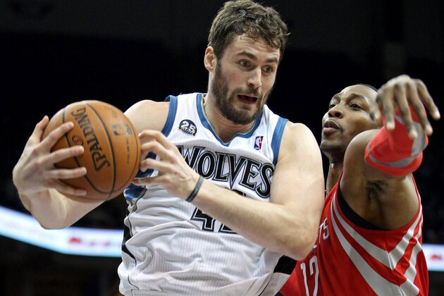 Feb 10, 2014; Minneapolis, MN, USA; Minnesota Timberwolves forward Kevin Love (42) grabs a rebound over Houston Rockets center Dwight Howard (12) during the second quarter at Target Center. Mandatory Credit: Brace Hemmelgarn-USA TODAY Sports