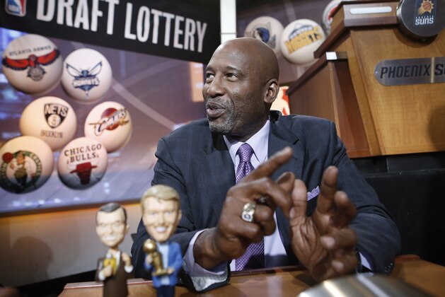 Basketball Hall of Famer James Worthy smiles before the start of the NBA basketball draft lottery in New York, Tuesday, May 20, 2014. Worthy brought bobblehead dolls of the late Lakers broadcaster Chick Hearn and the late Lakers owner Jerry Buss with him for good luck. (AP Photo/Kathy Willens)