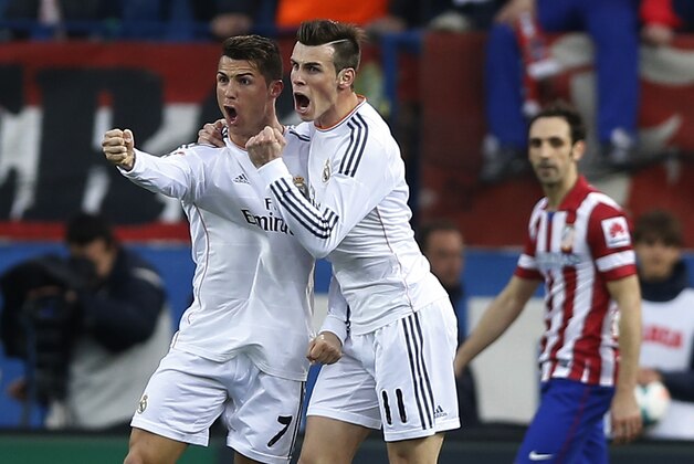 Real's Cristiano Ronaldo, left, celebrates his goal with teammate Gareth Bale, center, during a Spanish La Liga soccer match between Atletico de Madrid and Real Madrid at the Vicente Calderon stadium in Madrid, Spain, Sunday, March 2, 2014. (AP Photo/Andres Kudacki)