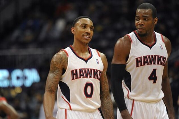 Atlanta Hawks guard Jeff Teague (0), who tied his career high with 34 points, and teammate Paul Millsap, who recorded his first career triple-double with 19 points, 13 rebounds and 2210 assists, walk off the court during overtime of their NBA basketball game against the Toronto Raptors Tuesday, March 18, 2014, in Atlanta. Atlanta won 118-113. (AP Photo/David Tulis)