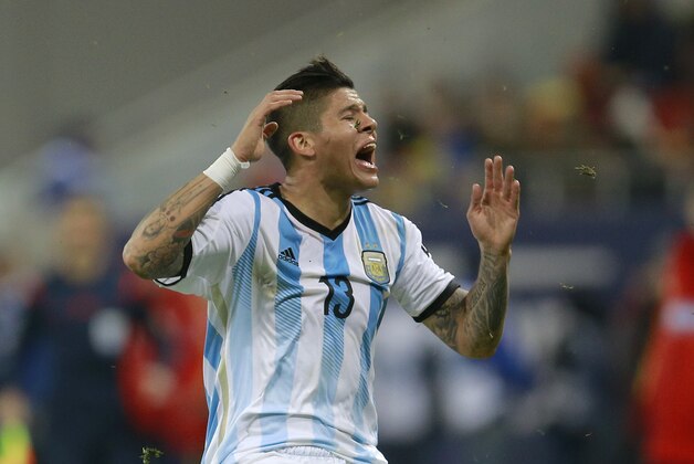 Argentina's Marcos Rojo reacts after receiving a blow to the head following a challenge by Romania's Alexandru Matel during an international friendly soccer game on the National Arena stadium in Bucharest, Romania, Wednesday, March 5, 2014.. (AP Photo/Vadim Ghirda)
