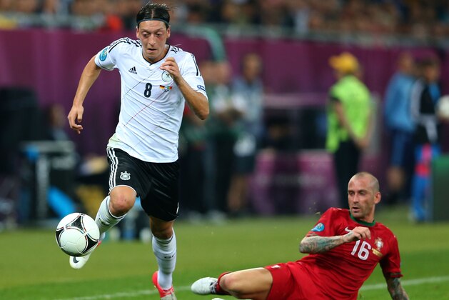 L'VIV, UKRAINE - JUNE 09: Mesut Ozil of Germany breaks past Raul Meireles of Portugal during the UEFA EURO 2012 group B match between Germany and Portugal at Arena Lviv on June 9, 2012 in L'viv, Ukraine.  (Photo by Alex Livesey/Getty Images)