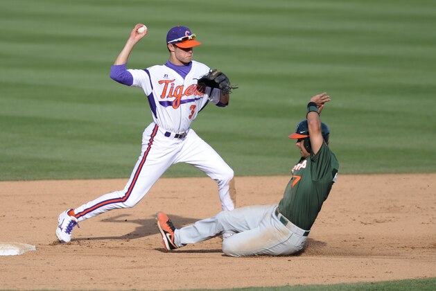 May 25, 2013; Durham, NC, USA; Clemson Tigers infielder Tyler Krieger (3) gets out Miami Hurricanes player Alexander Hernandez (7) at second base on a double play during the ACC baseball tournament at Durham Bulls Athletic Park. Miami won 7-0. Mandatory Credit: Liz Condo-USA TODAY Sports