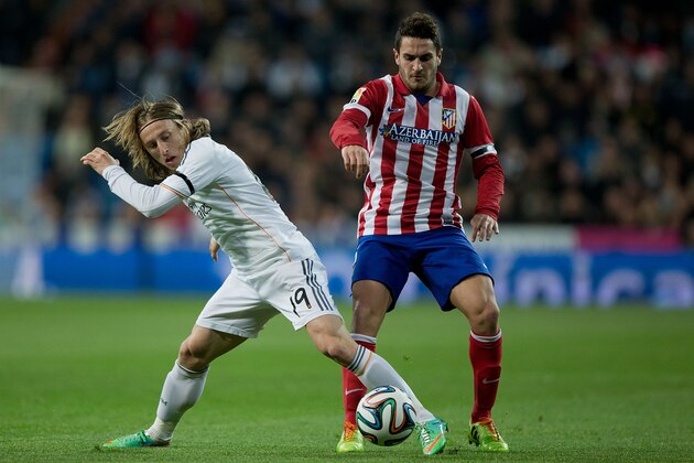 MADRID, SPAIN - FEBRUARY 05: Luka Modric (L) of Real Madrid CF competes for the ball with Koke (R) of Atletico de Madrid during the Copa del Rey semifinal first leg match between Real Madrid CF and Club Atletico Madrid at Estadio Santiago Bernabeu on February 5, 2014 in Madrid, Spain.  (Photo by Gonzalo Arroyo Moreno/Getty Images)