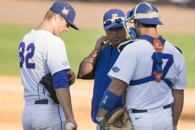 Florida coach Kevin O’Sullivan talks with pitcher Logan Shore, left, and catcher Taylor Gushue during the Southeastern Conference NCAA college baseball tournament game against Kentucky on Wednesday, May 21, 2014, in Hoover, Ala. (AP Photo/Hal Yeager)
