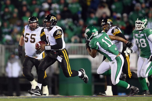 REGINA, SK - NOVEMBER 24:  Quarterback Henry Burris #1 of the Hamilton Tiger-Cats carries the ball while being pursued by Carlos Thomas #11 of the Saskatchewan Roughriders during the 101st Grey Cup Championship Game at Mosaic Stadium on November 24, 2013 in Regina, Canada.  (Photo by Jeff Gross/Getty Images)