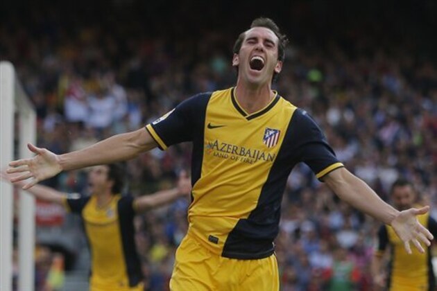 Atletico's Diego Godin from Uruguay, celebrates after scoring his side's first goal during a Spanish La Liga soccer match between FC Barcelona and Atletico Madrid at the Camp Nou stadium in Barcelona, Spain, Saturday, May 17, 2014. (AP Photo/Andres Kudacki)