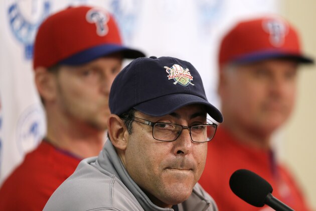 Philadelphia Phillies general manager Ruben Amaro Jr., center, speaks during a news conference as pitcher A.J. Burnett, left, and manager Ryne Sandberg, right, look on following a spring training baseball practice on Sunday, Feb. 16, 2014, in Clearwater, Fla. (AP Photo/Charlie Neibergall)