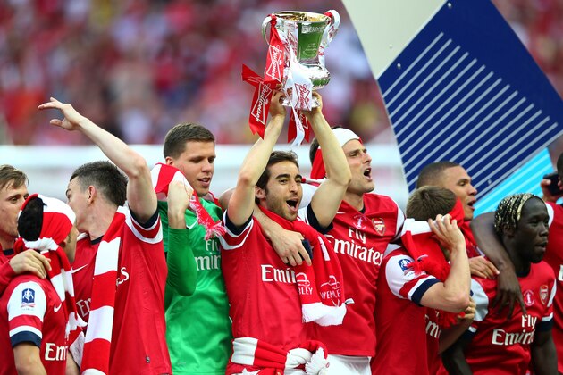 LONDON, ENGLAND - MAY 17:  Mathieu Flamini of Arsenal leads the trophy celebrations after the FA Cup with Budweiser Final match between Arsenal and Hull City at Wembley Stadium on May 17, 2014 in London, England.  (Photo by Clive Mason/Getty Images)
