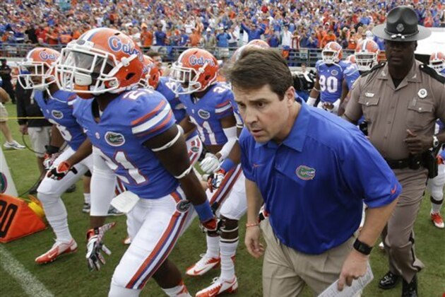 Florida head coach Will Muschamp, right, leads his team out on the field against Georgia during the first half of an NCAA college football game in Jacksonville, Fla., Saturday, Nov. 2, 2013.(AP Photo/John Raoux)