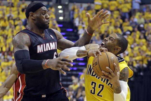 Miami Heat forward LeBron James, left, fouls Indiana Pacers guard C.J. Watson during the fourth quarter of Game 2 of the NBA basketball Eastern Conference finals in Indianapolis, Tuesday, May 20, 2014. The Heat defeated the Pacers 87-83 to tie the series at 1-1. (AP Photo/Michael Conroy)