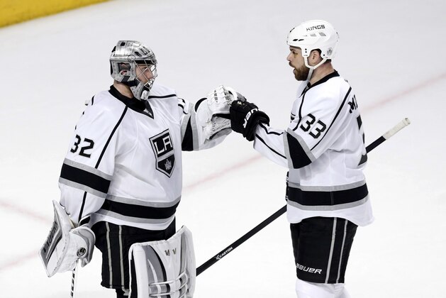 Los Angeles Kings defenseman Willie Mitchell (33)  celebrates the Kings' 6-2 win over the Chicago Blackhawks with goalie Jonathan Quick (32) after Game 2 of the Western Conference finals in the NHL hockey Stanley Cup playoffs Wednesday, May 21, 2014, in Chicago. (AP Photo/Charles Rex Arbogast)