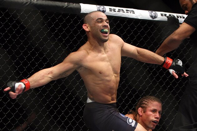 Renan Barao, left, of Brazil celebrates after the official called the fight against Urijah Faber of Sacramento, CA during the first  round of the Ultimate Fighting Bantamweight Championship Mixed Martial Arts bout in Newark, N.J. on Saturday, Feb. 1, 2014. Barao won after referee Herb Dean called the fight in the first round. (AP Photo/Tim Larsen)