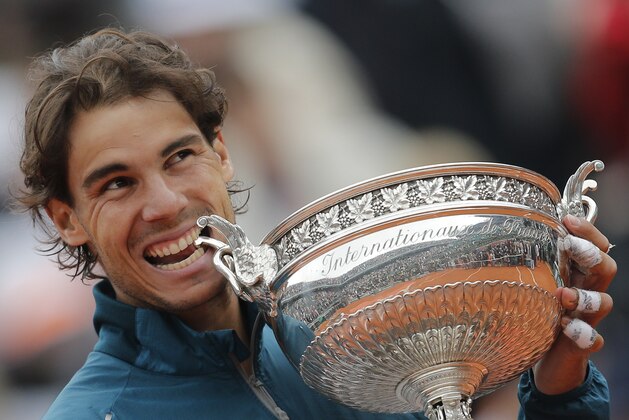 Spain's Rafael Nadal bites the trophy after winning against compatriot David Ferrer in three sets 6-3, 6-2, 6-3, in the final of the French Open tennis tournament, at Roland Garros stadium in Paris, Sunday June 9, 2013. (AP Photo/Christophe Ena)