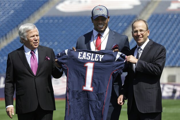 New England Patriots first-round draft choice Dominique Easley, center, displays a football jersey with Patriots Chairman and CEO Robert Kraft, left, and President Jonathan Kraft, right, Monday, May 12, 2014, at Gillette Stadium, in Foxborough, Mass. (AP Photo/Steven Senne)