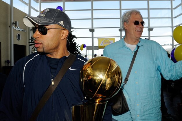 LOS ANGELES - JUNE 15:  Derek Fisher of the Los Angeles Lakers (L), carrying the Larry O'Brien Trophy,  and Lakers head coach Phil Jackson arrive at Los Angeles International Airport on June 15, 2009 in Los Angeles, California.  NOTE TO USER: User expressly acknowledges and agrees that, by downloading and/or using this Photograph, user is consenting to the terms and conditions of the Getty Images License Agreement. Mandatory Copyright Notice: Copyright 2009 NBAE (Photo by Juan Ocampo/NBAE via Getty Images)