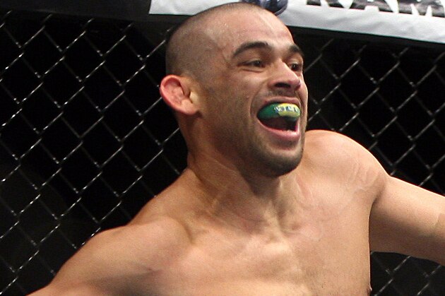 Renan Barao, left, of Brazil celebrates after the official called the fight against Urijah Faber of Sacramento, CA during the first  round of the Ultimate Fighting Bantamweight Championship Mixed Martial Arts bout in Newark, N.J. on Saturday, Feb. 1, 2014. Barao won after referee Herb Dean called the fight in the first round. (AP Photo/Tim Larsen)