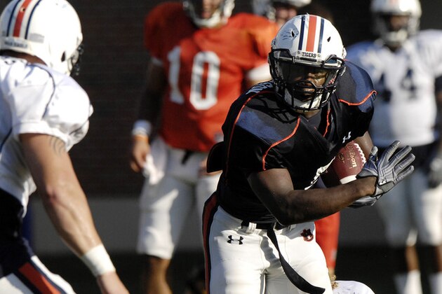 Auburn running back Jovon Robinson is tackled by defender Jake Holland during NCAA college football practice on Monday, Aug. 6, 2012 in Auburn, Ala.(AP Photo/Todd J. Van Emst)