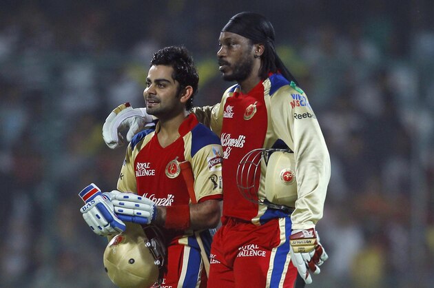 Chris Gayle, right, and Virat Kohli of Royal Challengers Bangalore walk back after their unbeaten 204 run second wicket partnership during their IPL cricket match against Delhi Daredevils, in New Delhi, India, Thursday, May 17, 2012. (AP Photo/ Saurabh Das)