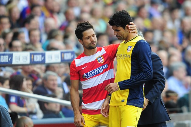 Atletico's Diego Ribas from Brazil, left, embraces teammate Diego Costa as he leaves the field after vein injured during a Spanish La Liga soccer match between FC Barcelona and Atletico Madrid at the Camp Nou stadium in Barcelona, Spain, Saturday, May 17, 2014. (AP Photo/Manu Fernandez)