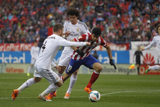 Atletico's Diego Costa, right, in action with Real's Sergio Ramos, left, during a Spanish La Liga soccer match between Atletico de Madrid and Real Madrid at the Vicente Calderon stadium in Madrid, Spain, Sunday, March 2, 2014. (AP Photo/Gabriel Pecot)