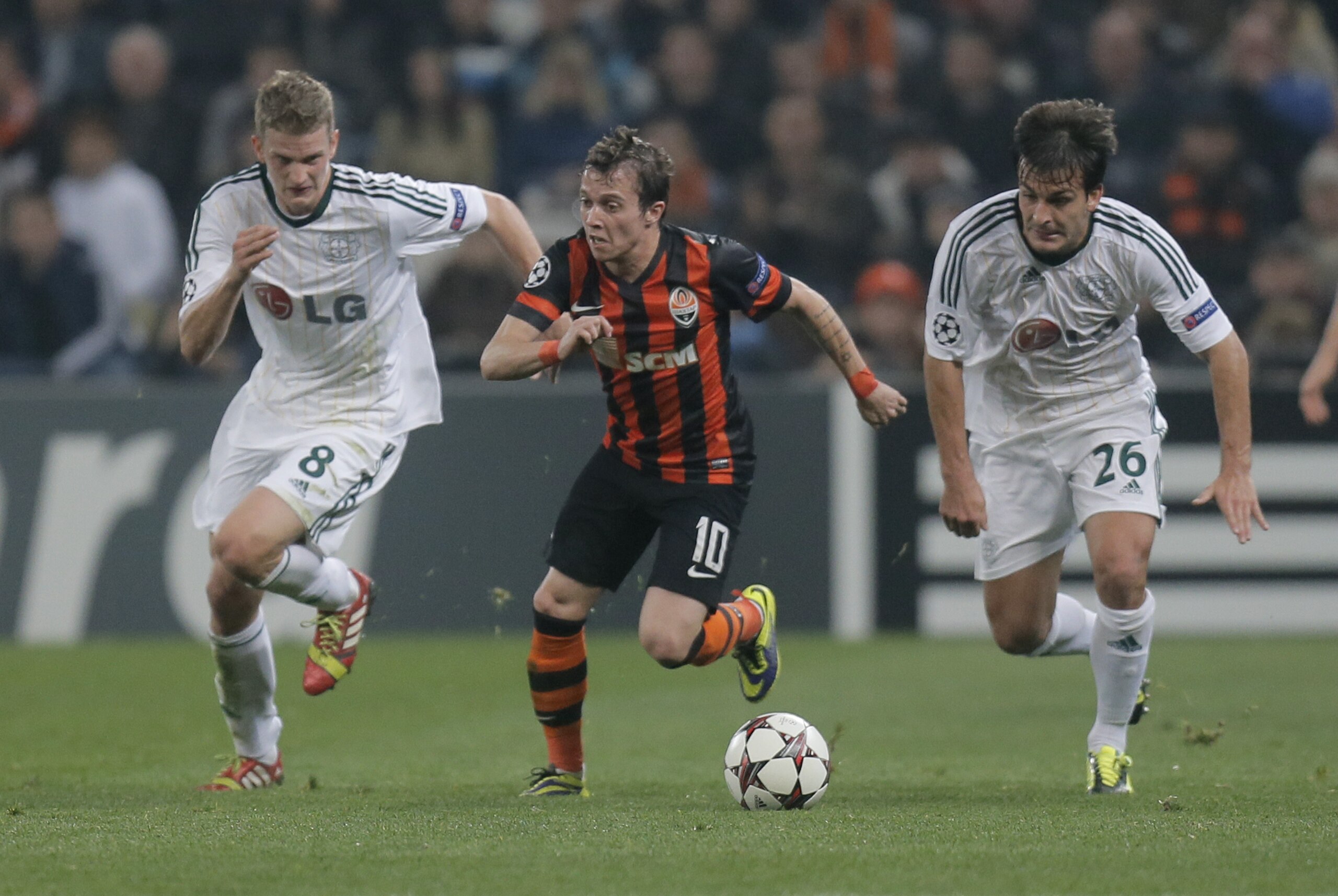 Donetsk's Bernard, center, Leverkusen's Lars Bender, left, and fellow team member Giulio Donati challenge for the ball during the Champions League group A soccer match between Bayer 04 Leverkusen and FC Shakhtar Donetsk at the Donbas Arena stadium in Donetsk, Ukraine, Tuesday, Nov. 5, 2013. (AP Photo/Efrem Lukatsky)