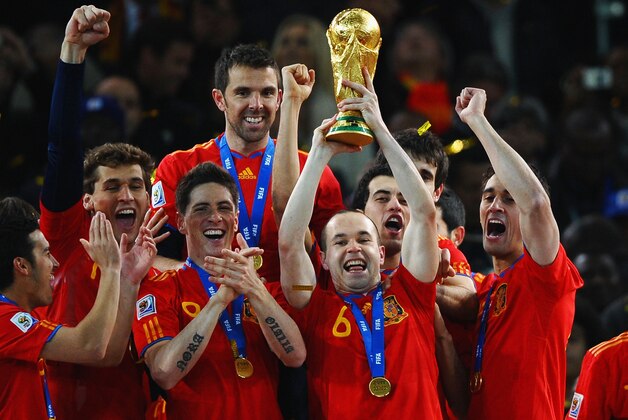 JOHANNESBURG, SOUTH AFRICA - JULY 11:  Goalscorer Andres Iniesta of Spain lifts the World Cup trophy as the Spain team celebrate victory  following the 2010 FIFA World Cup South Africa Final match between Netherlands and Spain at Soccer City Stadium on July 11, 2010 in Johannesburg, South Africa.  (Photo by Laurence Griffiths/Getty Images)