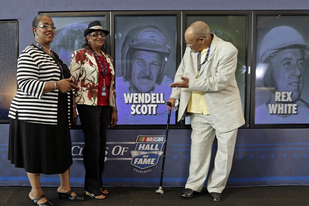 Wendell Scott Jr, right, Mable Scott, left, and Deborah Davis, center, pose for photos after Wendell Scott was named as one of five inductees into the NASCAR Hall of Fame class of 2015 during an announcement in Charlotte, N.C., Wednesday, May 21, 2014. (AP Photo/Chuck Burton)