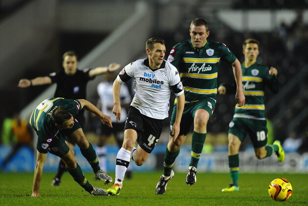 DERBY, ENGLAND - FEBRUARY 10: Craig Bryson of Derby County skips past Clint Hill and Richard Dunne of Queens Park Rangers during the Sky Bet Championship match between Derby County and Queens Park Rangers on February 10, 2014 in Derby, England.  (Photo by Laurence Griffiths/Getty Images)