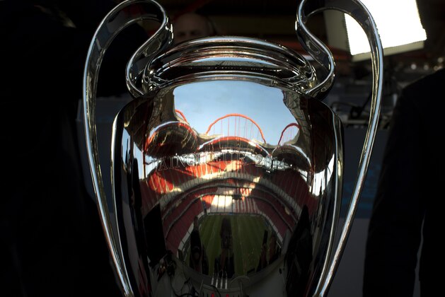 The pitch is reflected in the Champions League trophy, during a training session ahead of Saturday's Champions League final soccer match between Real Madrid and Atletico Madrid, in Luz stadium in Lisbon, Portugal, Friday, May 23, 2014. (AP Photo/Emilio Morenatti)