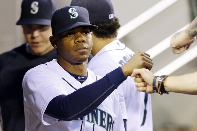 Seattle Mariners pitcher Roenis Elias is greeted in the dugout Thursday, May 22, 2014, after he was pulled from a baseball game against the Houston Astros in Seattle. (AP Photo/Ted S. Warren)