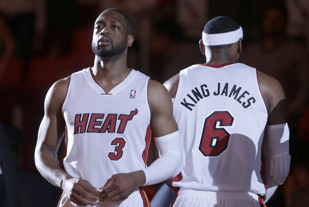Miami Heat guard Dwyane Wade (3) and forward LeBron James (6) stand during player introductions before the start of an NBA basketball game against the Brooklyn Nets, Wednesday, March 12, 2014 in Miami. (AP Photo/Wilfredo Lee)