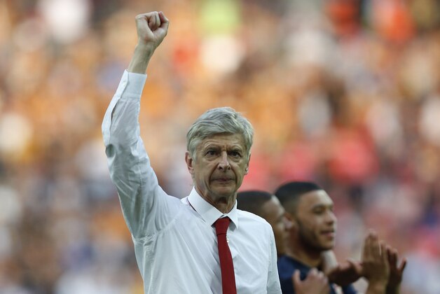 Arsenal's manager Arsene Wenger punches the air in celebration of their win against Hull City at the end of their English FA Cup final soccer match at Wembley Stadium in London, Saturday, May 17, 2014. (AP Photo/Sang Tan)