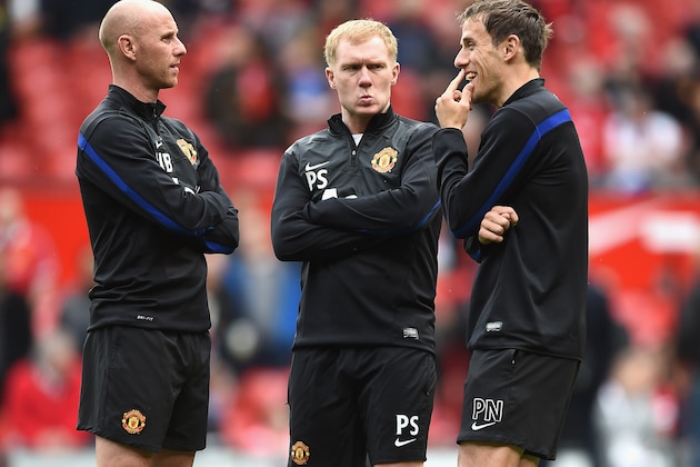 MANCHESTER, ENGLAND - APRIL 26:  l-r Nicky Butt, Paul Scholes and Phil Neville of Manchester United watch over the players during warm up during the Barclays Premier League match between Manchester United and Norwich City at Old Trafford on April 26, 2014 in Manchester, England.  (Photo by Laurence Griffiths/Getty Images)