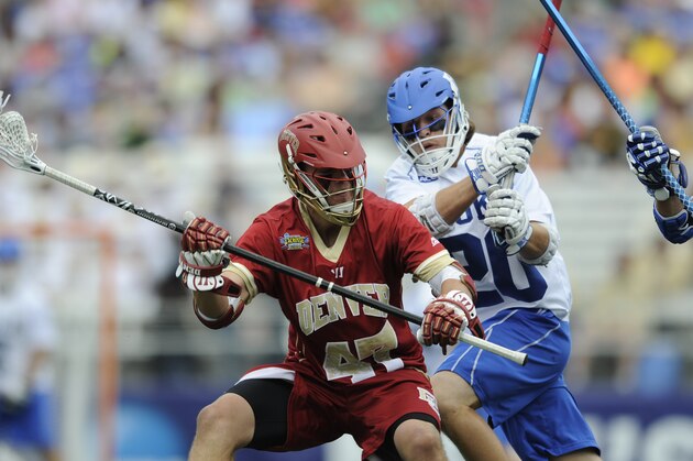 Denver's  Jake Nolan looks to pass the ball under pressure from Duke's Charlie Payton in the second half of an NCAA semi-final lacrosse game Saturday, May 24, 2014, in Baltimore. Duke won 15-12.(AP Photo/Gail Burton)