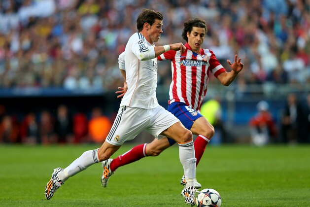 LISBON, PORTUGAL - MAY 24:  Gareth Bale of Real Madrid runs through on goal under the watchful eye of Tiago of Club Atletico de Madrid during the UEFA Champions League Final between Real Madrid and Atletico de Madrid at Estadio da Luz on May 24, 2014 in Lisbon, Portugal.  (Photo by Alex Livesey/Getty Images)