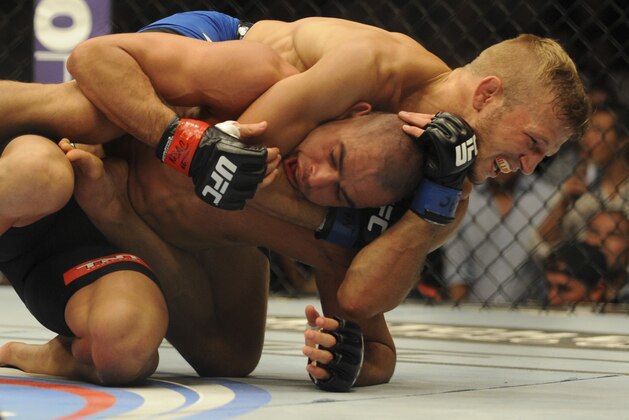 May 24, 2014; Las Vegas, NV, USA; Bantamweight Champion Renan Barao (red) struggles to break free of TJ Dillashaw's (blue) choke hold during their UFC 173 bantamweight championship bout at MGM Grand Garden Arena. Dillashaw won by way of TKO. Mandatory Credit: Stephen R. Sylvanie-USA TODAY Sports