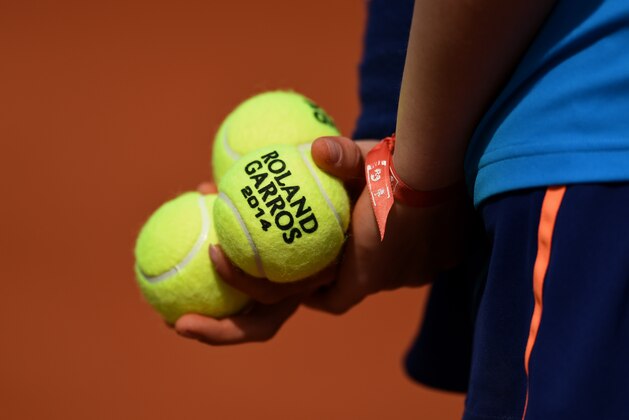 PARIS, FRANCE - MAY 25:  A ballboy holds Roland Garros 2014 tennis balls during a match on day one of the French Open at Roland Garros on May 25, 2014 in Paris, France.  (Photo by Matthias Hangst/Getty Images)
